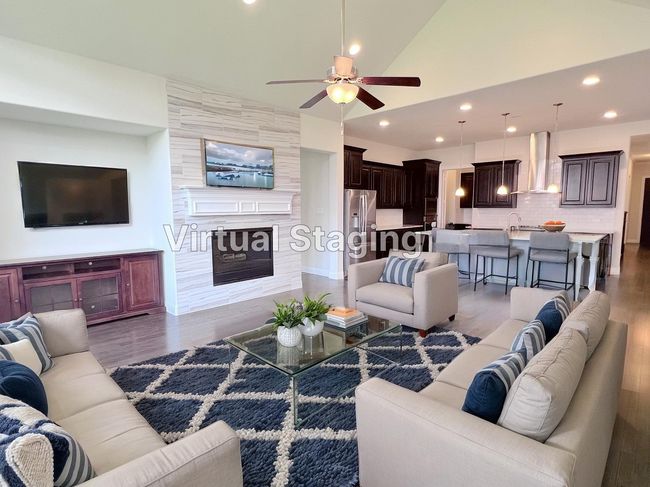 Living area with a ceiling fan, wood finished floors, recessed lighting, a large fireplace, and vaulted ceiling | Image 20