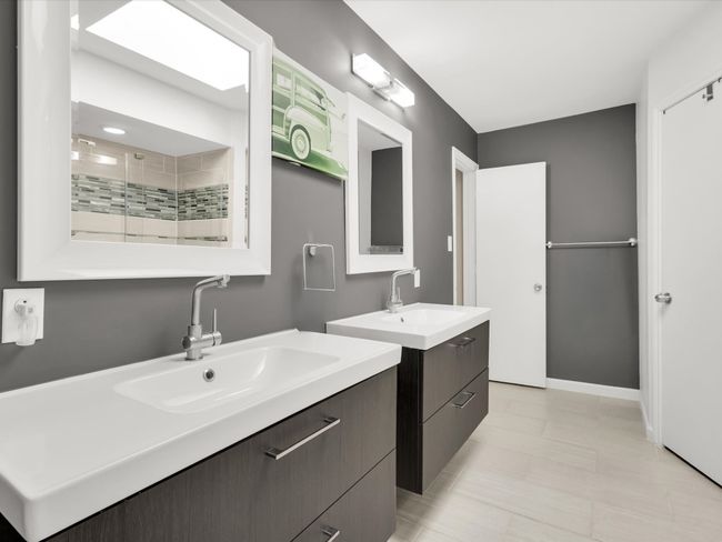 Full bathroom featuring a tile shower, two vanities, and tile patterned floors | Image 18