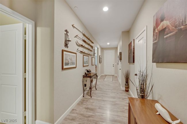 Hallway with light wood-style flooring, baseboards, and recessed lighting | Image 5