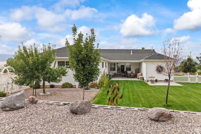 Rear view of house with a patio area and a shingled roof | Image 92
