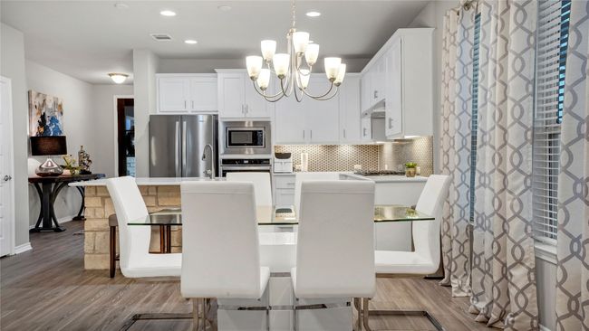 Kitchen with visible vents, wood finished floors, a chandelier, and stainless steel appliances | Image 12