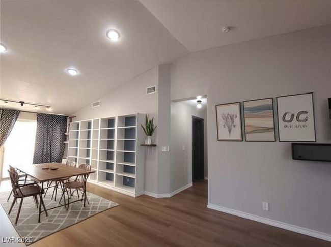 Dining space with lofted ceiling and wood finished floors | Image 5