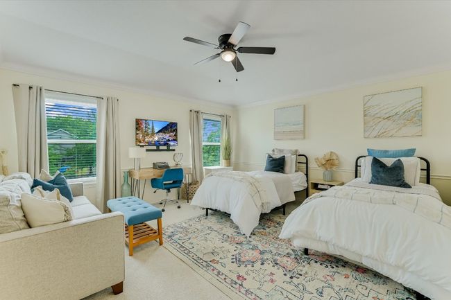 Carpeted bedroom with multiple windows, crown molding, and a ceiling fan | Image 25