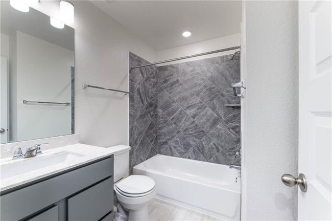 Bathroom featuring vanity and washtub / shower combination | Image 18