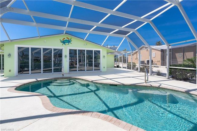 Outdoor pool with a lanai and a patio with ample room for relaxing poolside. | Image 16