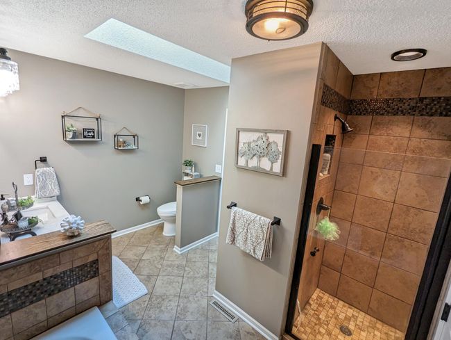 Spacious custom tiled bath with double sinks. | Image 17