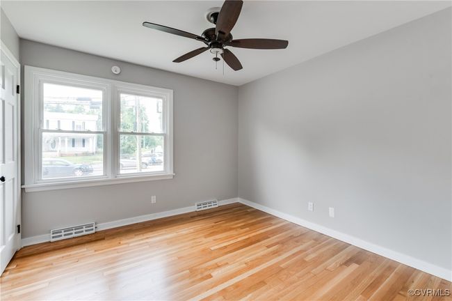 Unfurnished room with ceiling fan, wood finished floors, and a smoke detector | Image 11