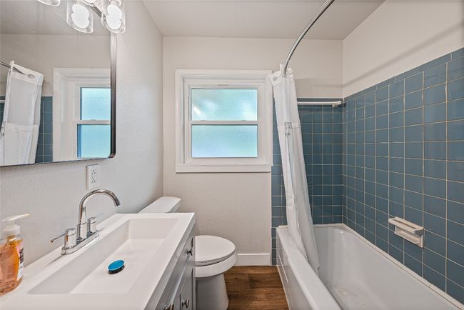 Full bath featuring vanity, wood finished floors, and shower / bathtub combination with curtain | Image 10