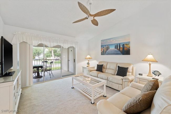 Living area with light carpet, vaulted ceiling, and a ceiling fan | Image 8