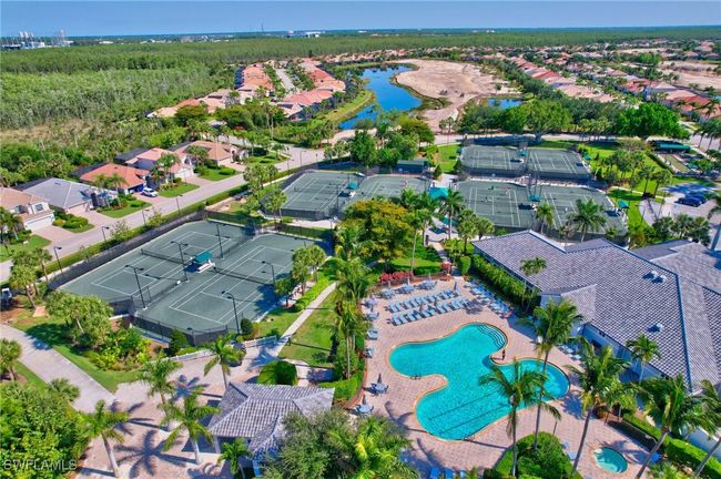 Aerial view of property and surrounding area featuring a large body of water, a pool area, and nearby suburban area | Image 49