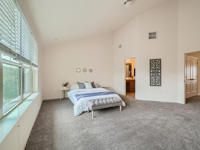Bedroom featuring high vaulted ceiling, carpet flooring, and ensuite bath | Image 7