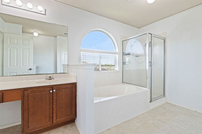 Bathroom featuring a garden tub, a shower stall, and vanity | Image 6