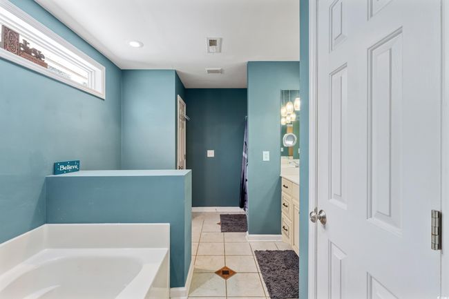 Bathroom featuring vanity, a bath, and tile patterned floors | Image 22