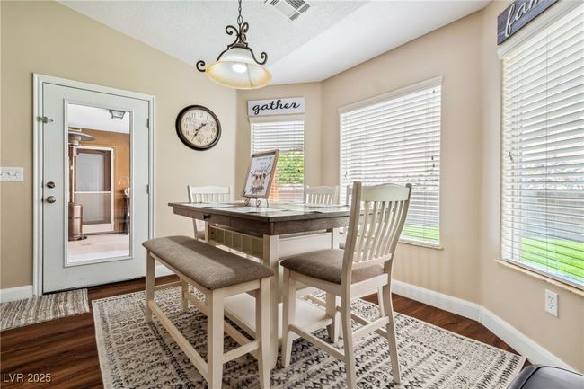 Dining room with dark wood-type flooring, baseboards, a textured ceiling, and lofted ceiling | Image 19
