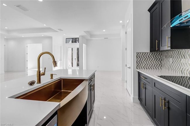 Kitchen featuring range hood, a raised ceiling, tasteful backsplash, and light tile patterned floors | Image 19