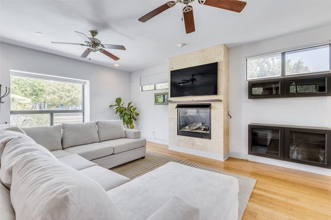 Living room with wood-type flooring and a tiled fireplace | Image 4