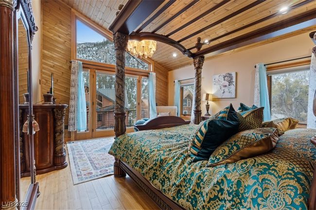 Bedroom with a chandelier, high vaulted ceiling, wooden ceiling, hardwood / wood-style flooring, and access to outside | Image 56