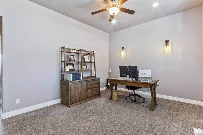 Carpeted office with visible vents, baseboards, and ceiling fan | Image 4