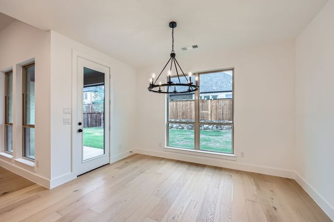 Unfurnished dining area featuring light wood finished floors, visible vents, baseboards, and a notable chandelier | Image 7