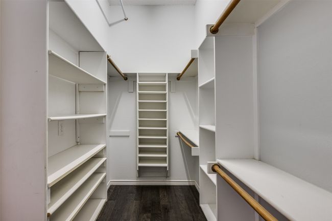 Spacious closet with dark wood-style flooring | Image 18