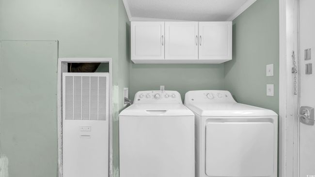 Laundry area with a heating unit, cabinet space, washer and clothes dryer, and a textured ceiling | Image 9