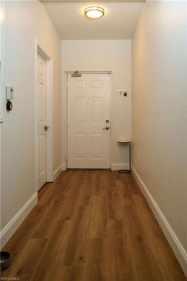 Hallway featuring dark wood-style flooring and baseboards | Image 26