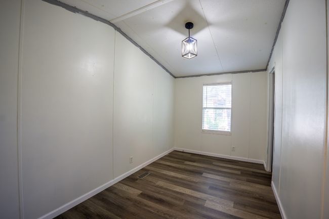 Spare room with vaulted ceiling and dark wood-style flooring | Image 23