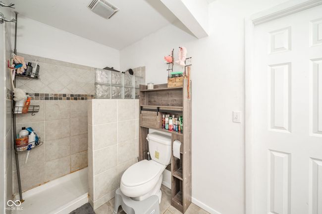 bathroom with a tile shower and tile patterned flooring | Image 20