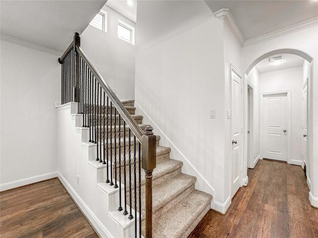 Ascend the carpeted staircase to the second floor, where you'll find three spacious bedrooms in addition to the luxurious primary suite. | Image 6