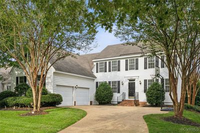 Colonial inspired home with a garage and a front yard | Image 1