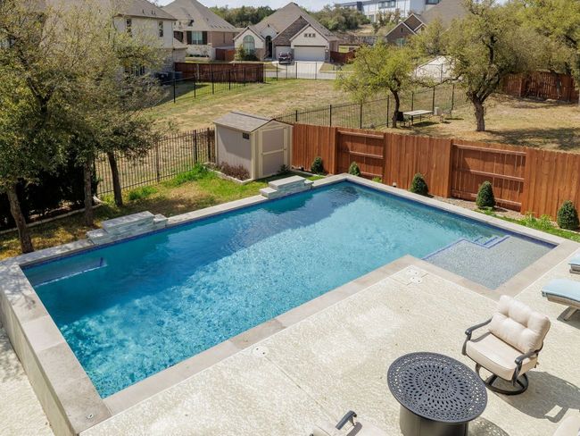 View of pool featuring a storage shed, a fenced in pool, a fenced backyard, a residential view, and an outbuilding | Image 30