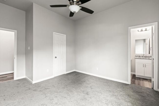 Bedroom featuring ensuite bathroom, ceiling fan, sink, carpet floors, and a closet | Image 19