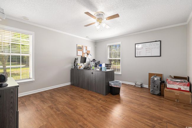 Office featuring ceiling fan, plenty of natural light, ornamental molding, a textured ceiling, and dark wood-style flooring | Image 17