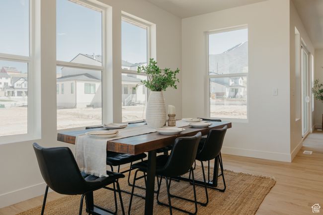 Dining area with visible vents, light wood-style flooring, baseboards, and a healthy amount of sunlight | Image 5