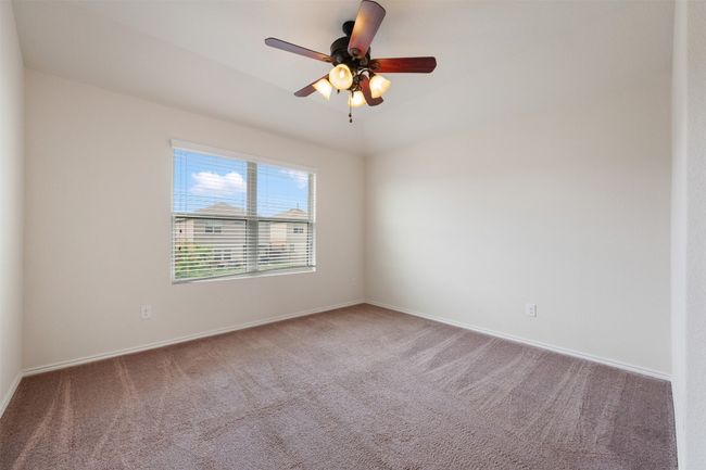 Spare room with carpet flooring, baseboards, and ceiling fan | Image 23
