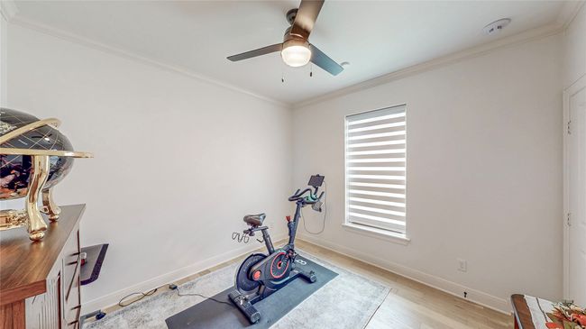 Exercise area with a ceiling fan, light wood finished floors, and crown molding | Image 31