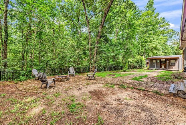 View of yard featuring an outdoor fire pit and a wooded view | Image 36