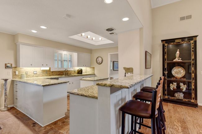 Kitchen with a peninsula, a sink, white cabinetry, and recessed lighting | Image 13