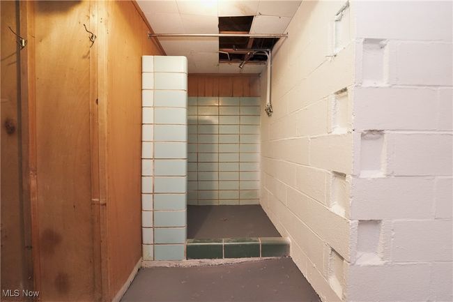 Full bathroom with concrete floors, concrete block wall, and tiled shower | Image 36
