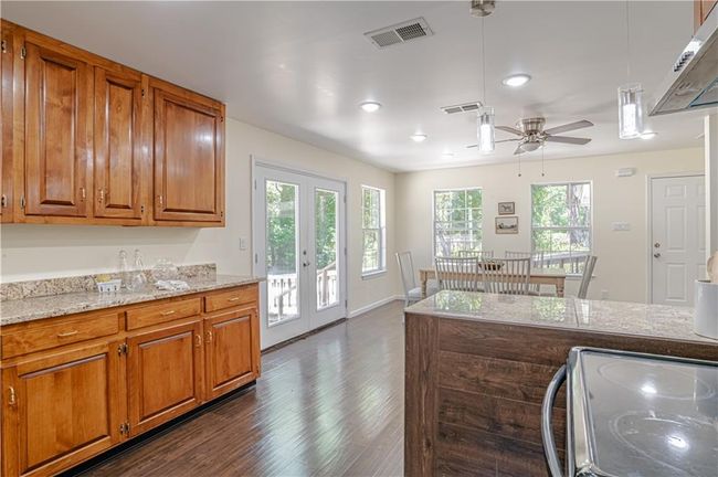Kitchen featuring ceiling fan, stove, dark hardwood / wood-style floors, and a healthy amount of sunlight | Image 25