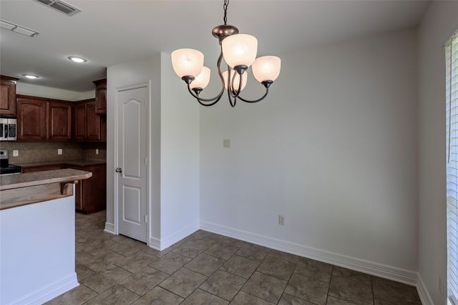 Kitchen featuring pendant lighting, backsplash, baseboards, appliances with stainless steel finishes, and visible vents | Image 20
