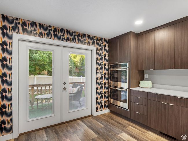 Kitchen with double oven, french doors, light countertops, wood finished floors, and modern cabinets | Image 17