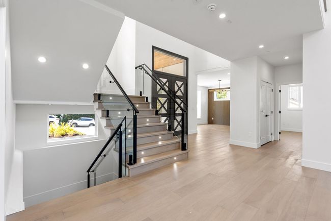 Staircase featuring a notable chandelier, recessed lighting, baseboards, and wood finished floors | Image 30