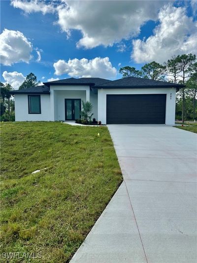 Ranch-style home featuring a garage and a front lawn | Image 2