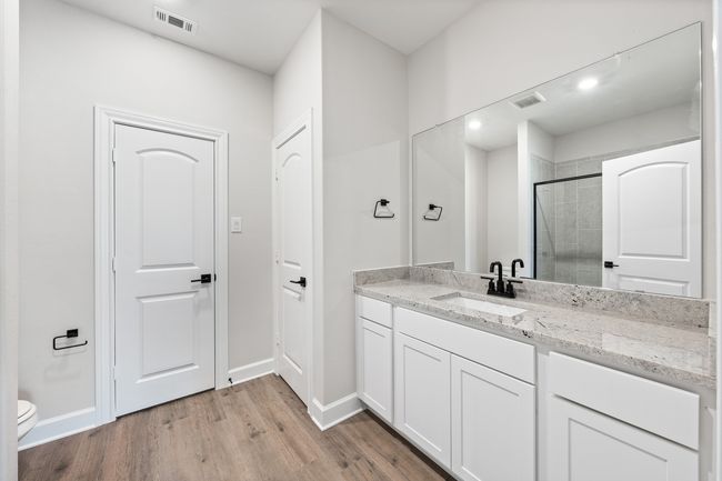 Bathroom with toilet, walk in shower, hardwood / wood-style flooring, and vanity | Image 6