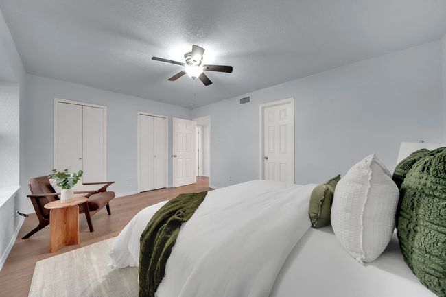 Bedroom featuring multiple closets, wood finished floors, and a ceiling fan | Image 11