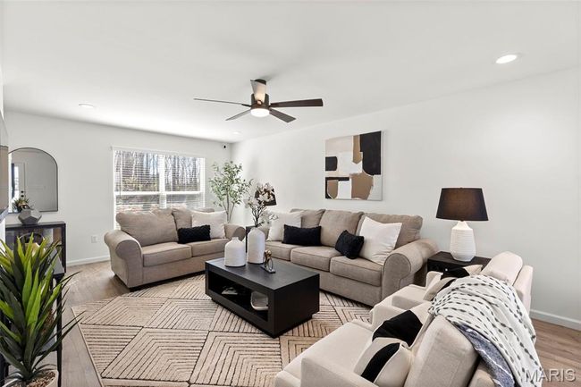 Living room featuring ceiling fan, light wood-type flooring, baseboards, arched walkways, and recessed lighting | Image 5