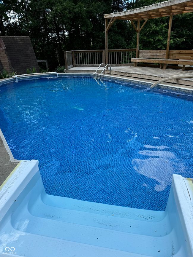 outdoor pool with view of scattered trees | Image 4
