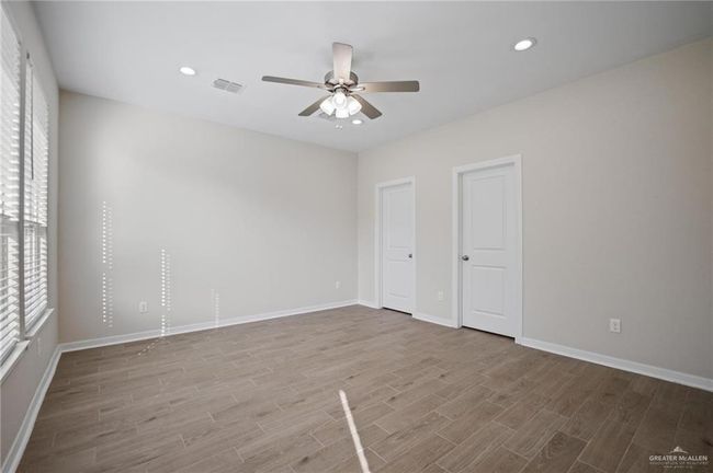 Unfurnished bedroom featuring wood finished floors, multiple windows, recessed lighting, and a ceiling fan | Image 7