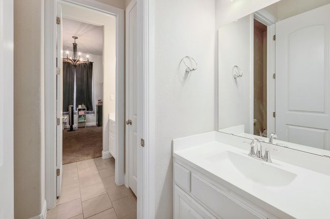Bathroom with vanity, tile patterned floors, and a chandelier | Image 26